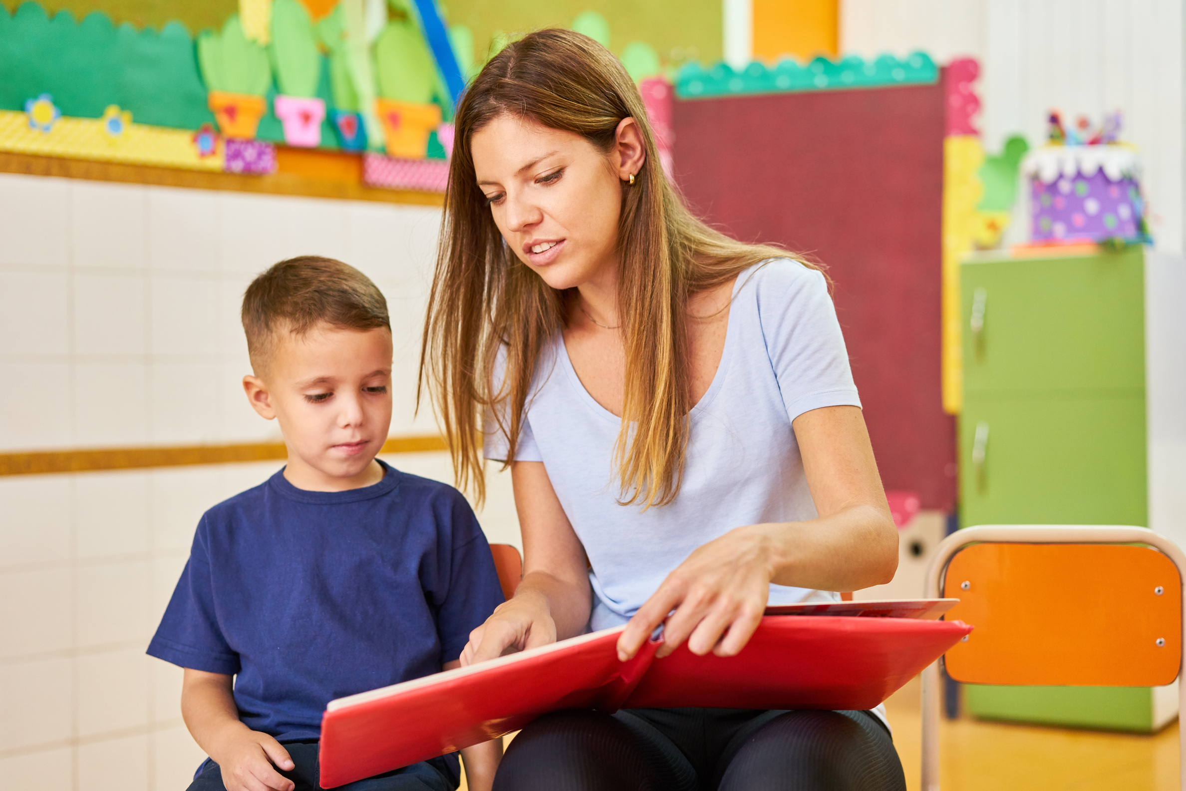 Kindergarten Teacher or Childminder Reading Aloud While Reading